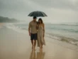 Couple walking under an umbrella on a rainy day at Nusa Dua beach Bali