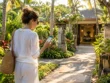 Hotel guest checking her phone while walking up to a spa entrance within walking distance in Nusa Dua