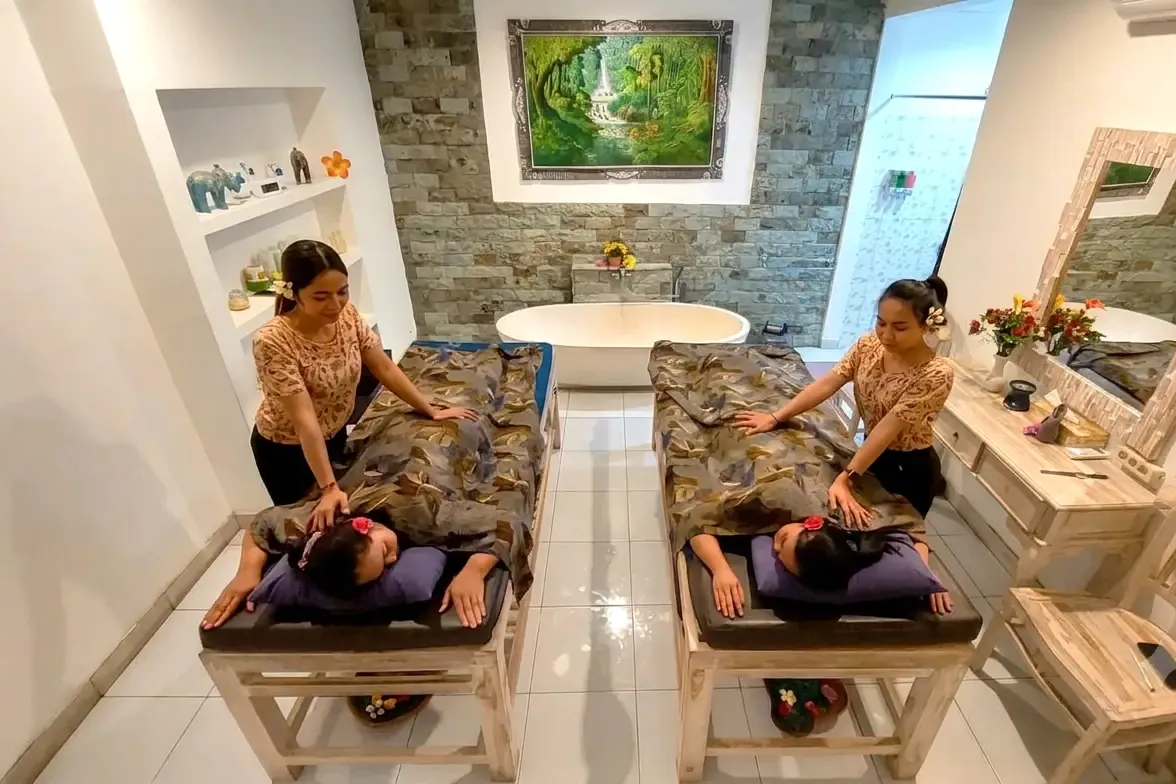 Two therapists giving a couple's massage in a private treatment room